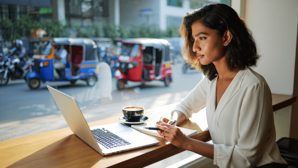 Beautiful Young Woman With a Flower on Her Head is Working Online on a Laptop Next to the Swimming Pool and Scenic Background Near Galle, Sri Lanka