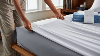 Green sateen sheets on a bed with a yellow striped pillow
