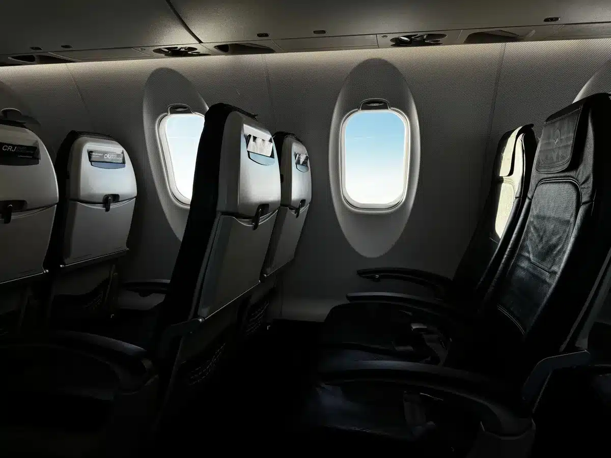 Passengers in airplane cabin enjoying comfortable seating with window views during long-haul flight