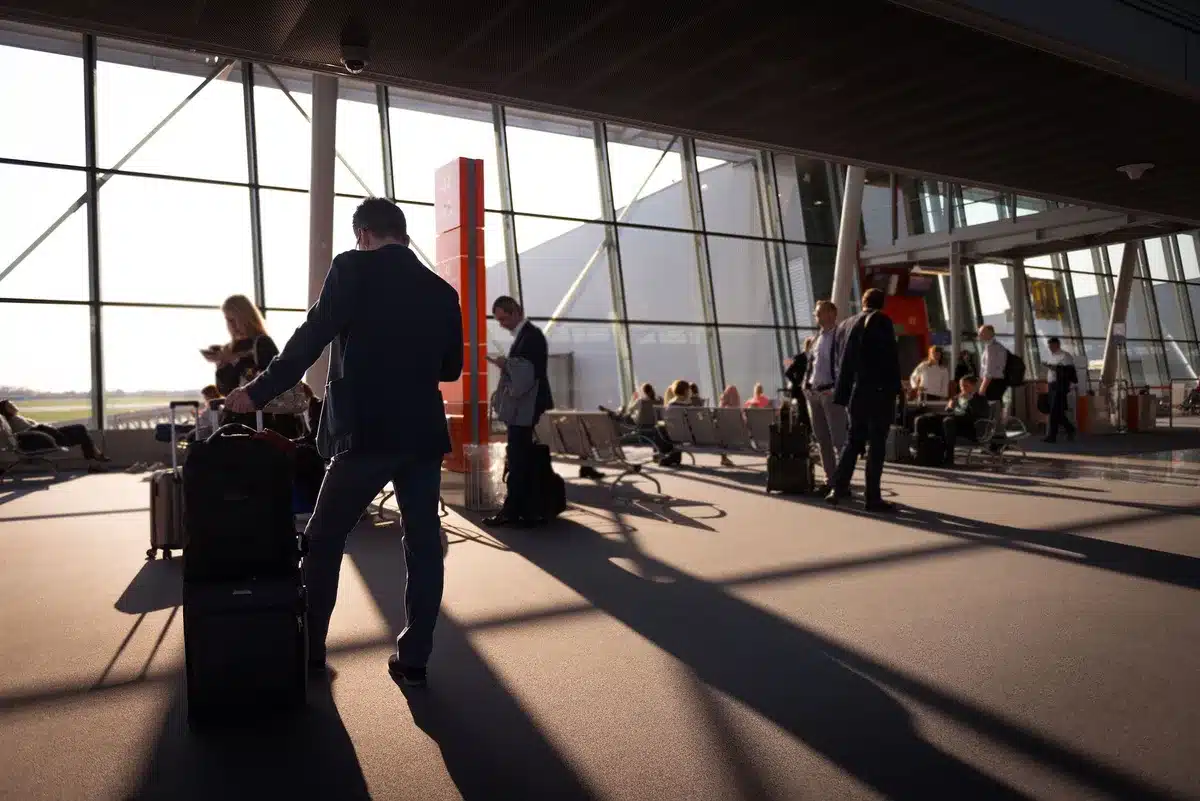 Business traveler with luggage at airport terminal