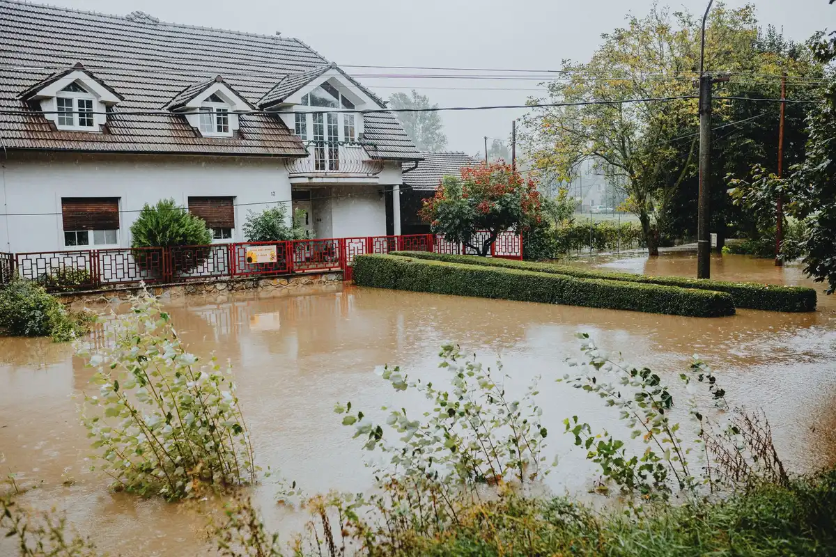 Muddy festival campground with flooded areas and storm damage across open farmland