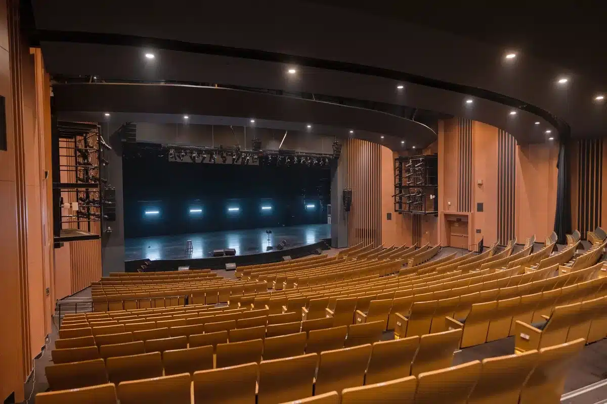 Historic theater interior with ornate vintage details and empty seats under stage lighting