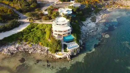 Oceanfront resort pool and deck overlooking turquoise Caribbean waters at sunset