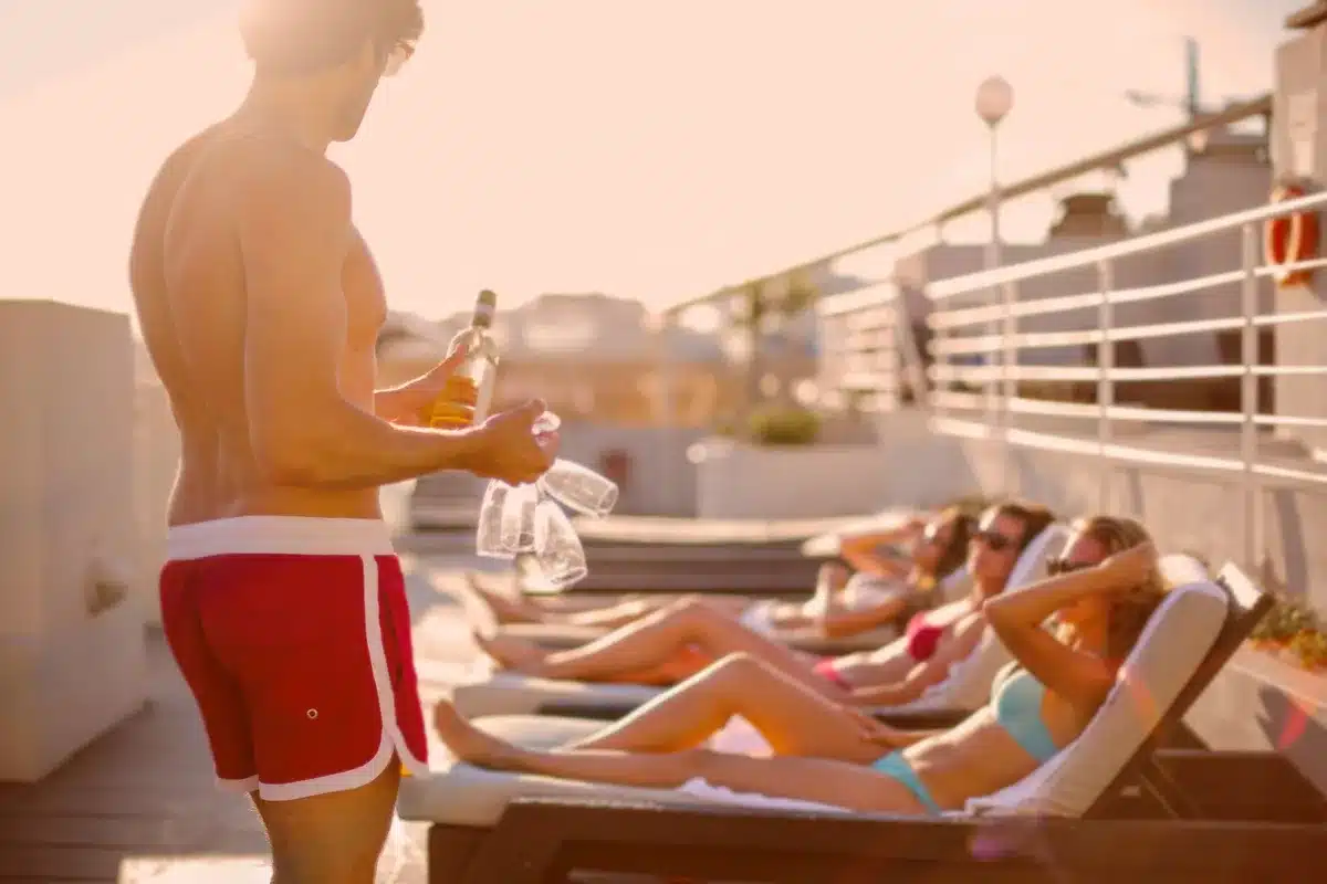 Upscale beachfront resort with lounge seating, cocktails, and ocean view at sunset