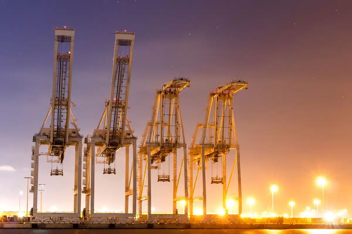 Large construction cranes and equipment at an airport terminal site under active renovation