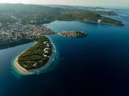 Luftaufnahme einer kroatischen Insel mit türkisfarbenen Buchten, Felsklippen und mittelalterlichem Hafen