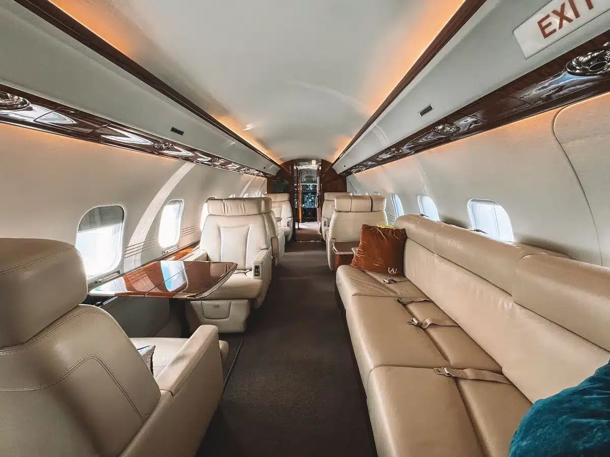 Interior of a modern aircraft cabin with premium seating and in-flight entertainment screens