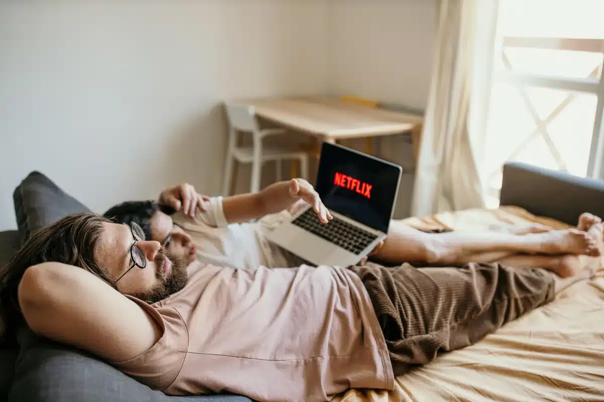 A person relaxing at home watching Netflix on a television screen in a comfortable living room setting