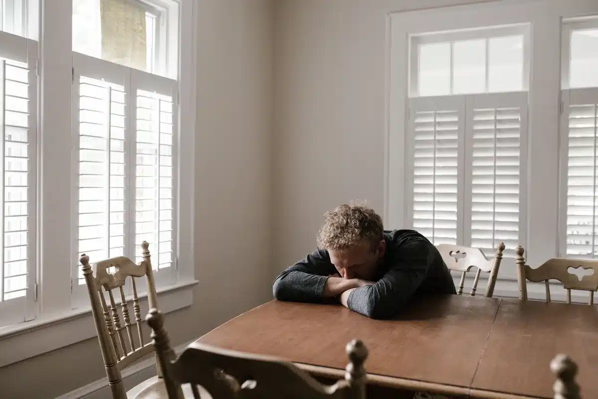 A person sitting alone looking tired, representing the emotional toll of caregiving