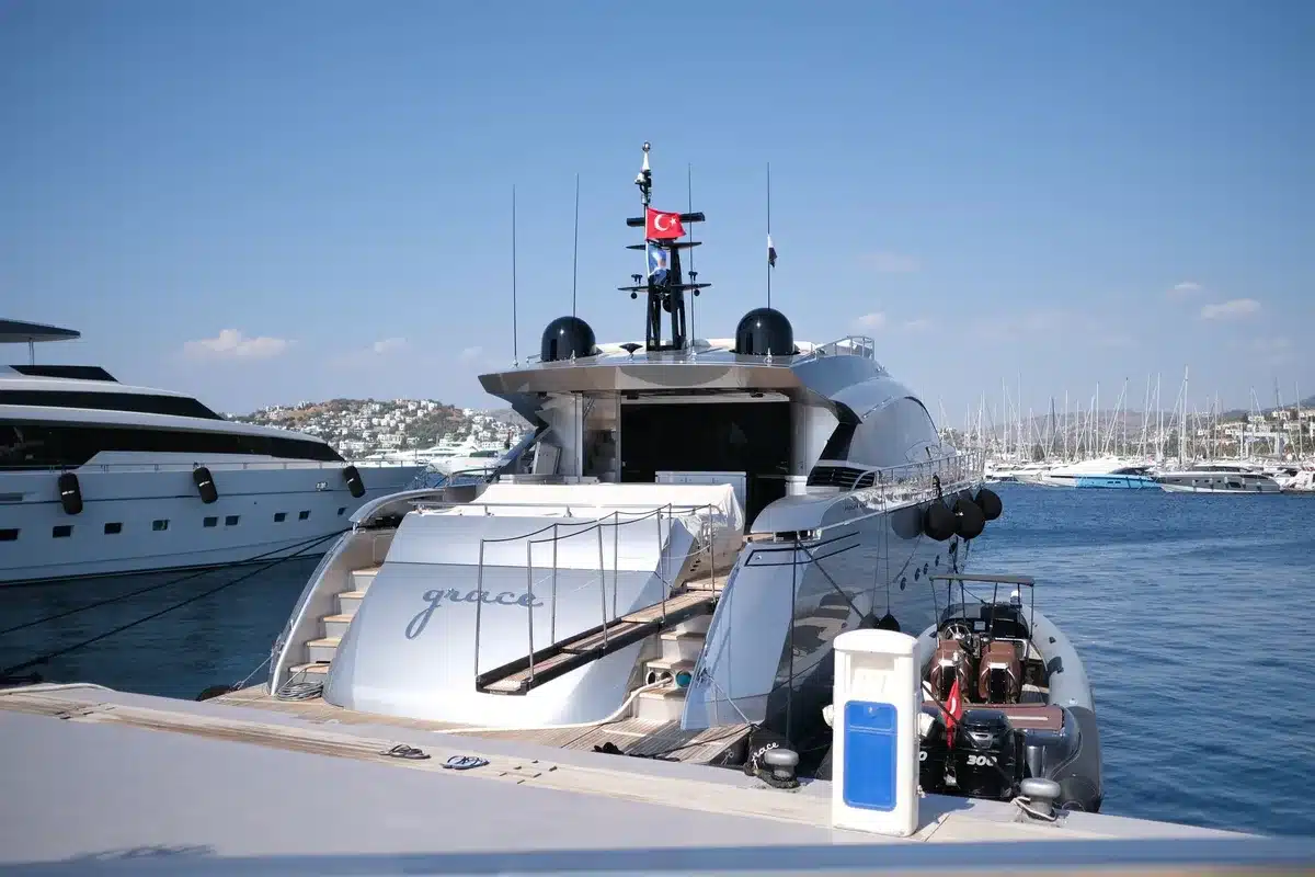 Woman in leopard-print designer bikini and miniskirt relaxing on a yacht deck overlooking Mediterranean waters