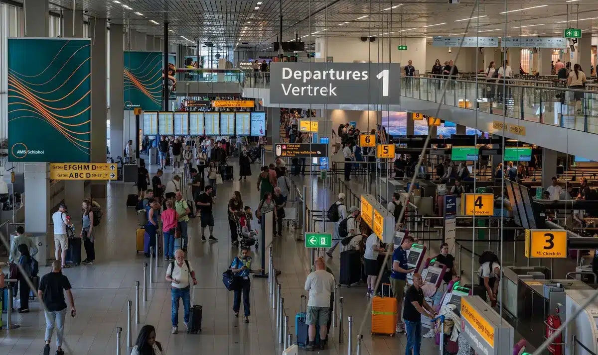 Travelers navigating a crowded airport terminal with busy passenger flow