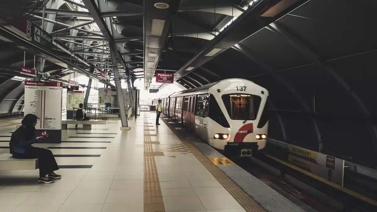 Passengers walking through a modern airport terminal near an automated people mover system