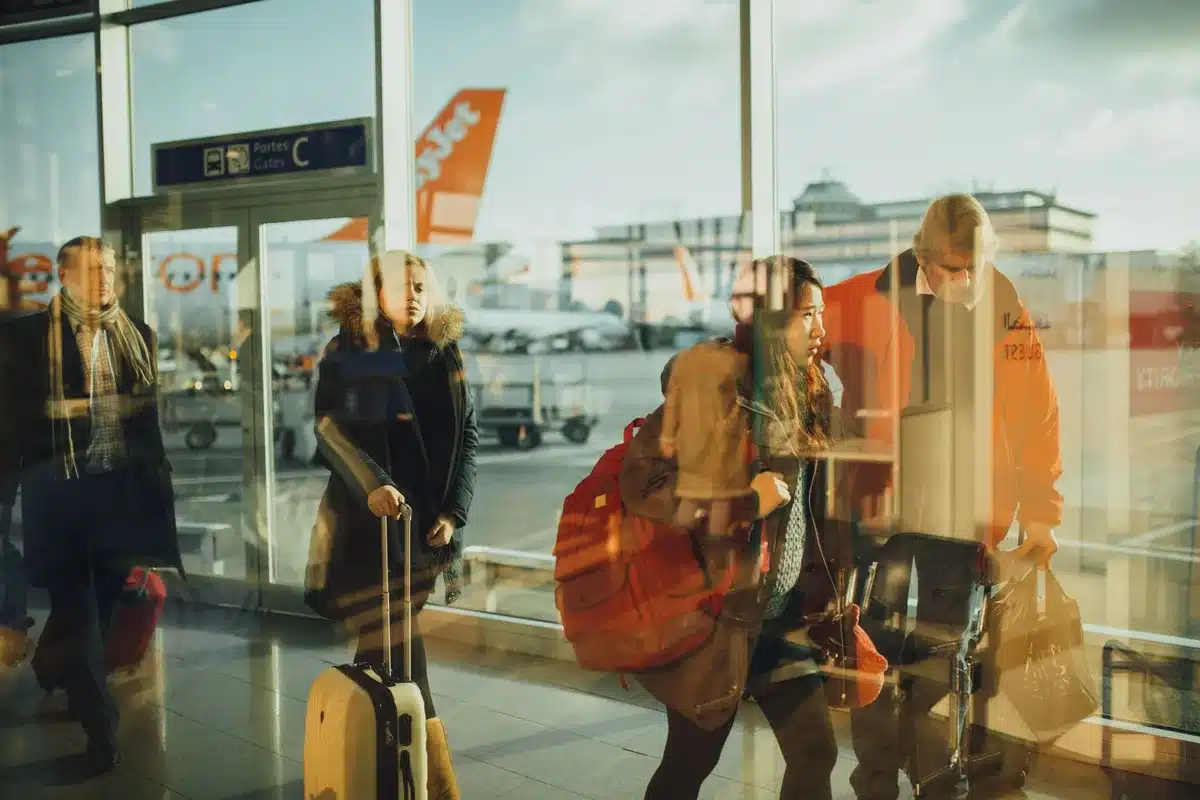 Business traveler boarding an airplane with carry-on luggage at the gate