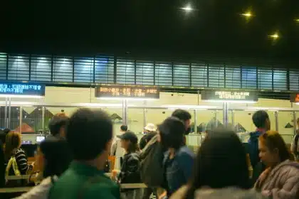Customers waiting in line outside a modern frozen yogurt shop with bright signage