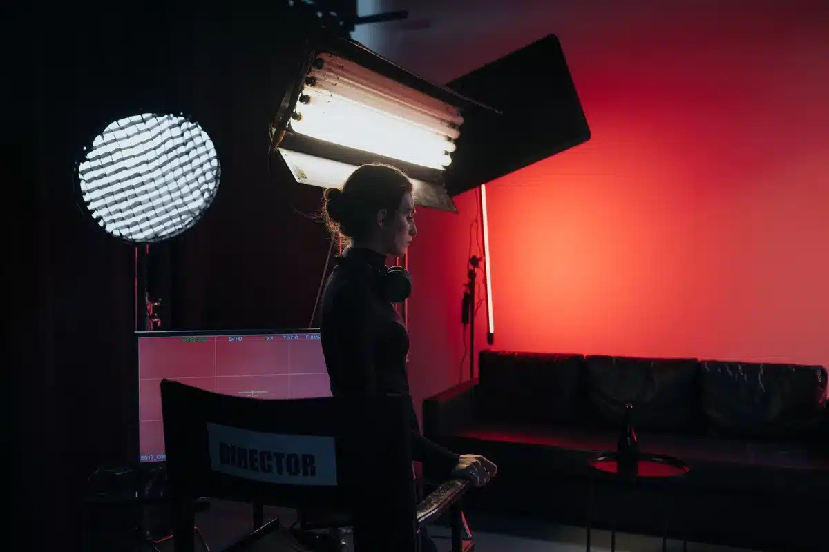 Female executive producer on television set reviewing script with crew members