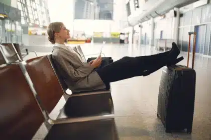 Modern airport lounge interior with comfortable seating, work desk, and natural lighting
