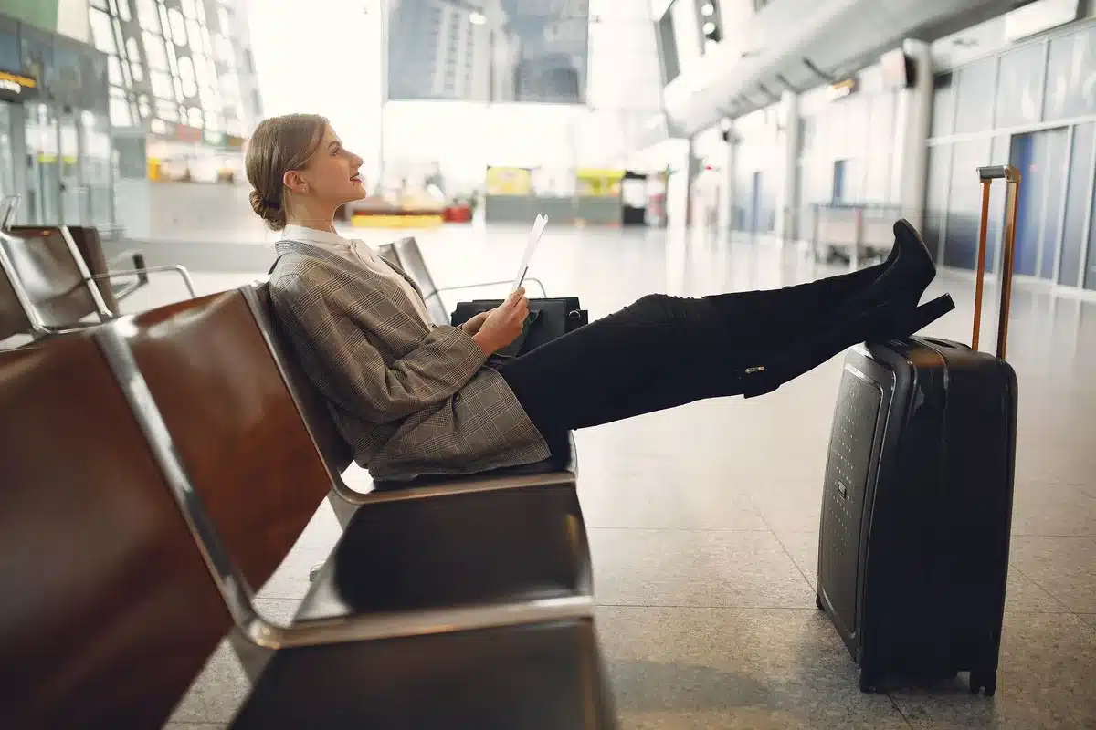 Modern airport lounge interior with comfortable seating, work desk, and natural lighting