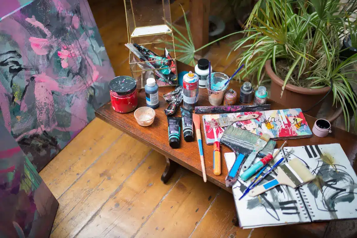 An artist's studio with paintings and personal artwork displayed on walls.