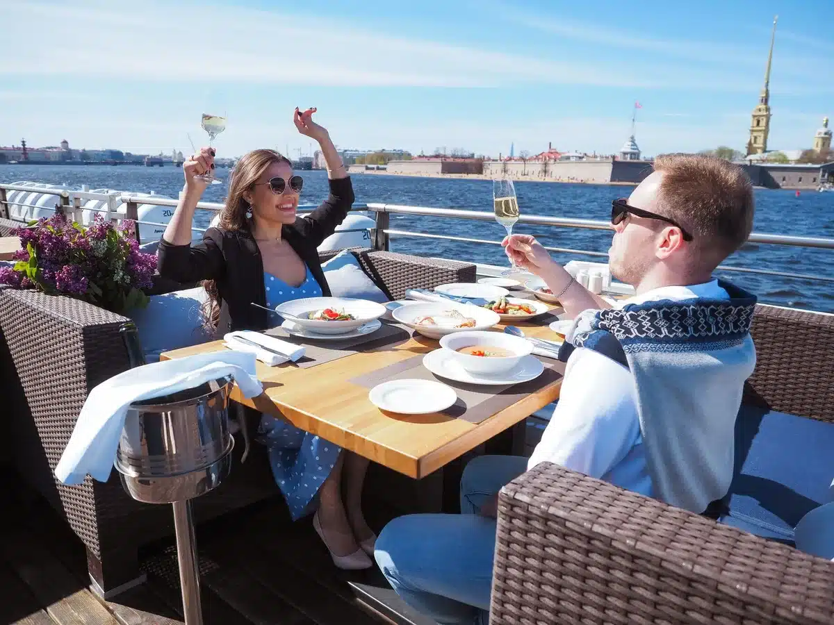 Zwei Personen beim Trinken an einem malerischen europäischen Ort mit Blick auf das Wasser