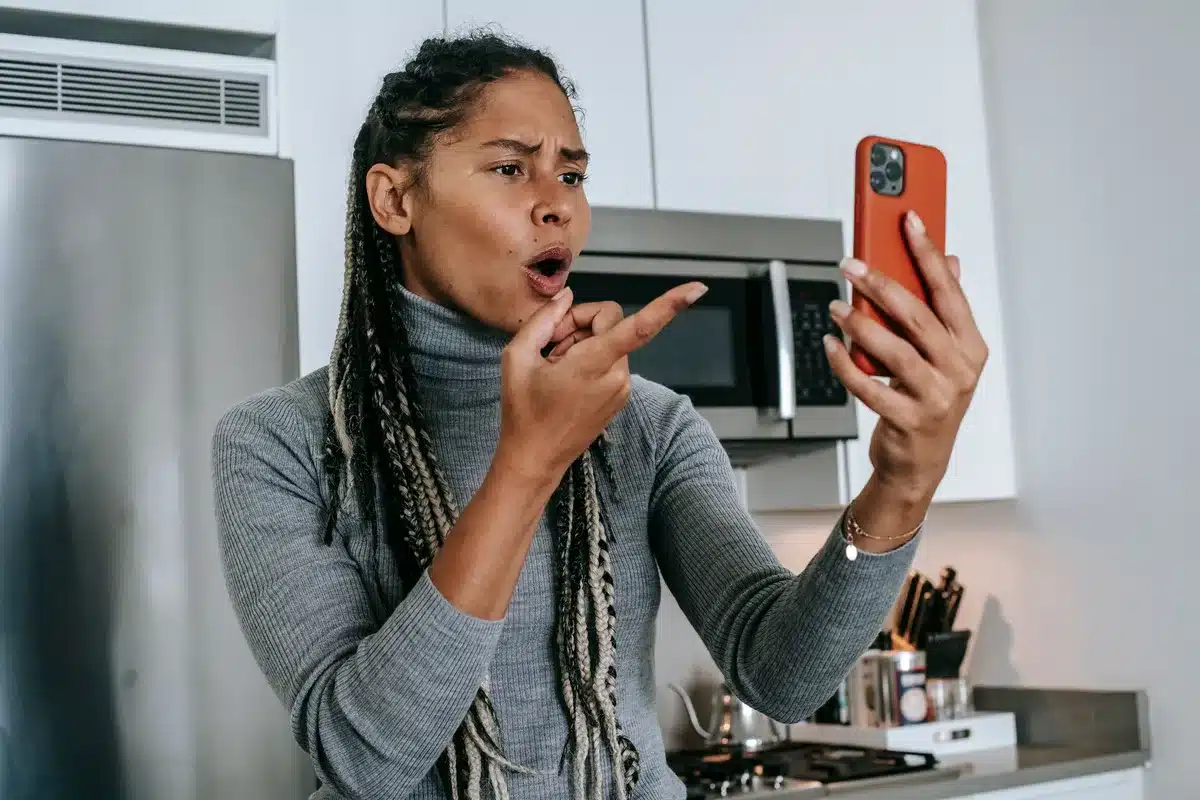 Persona que escribe un mensaje crítico en redes sociales, mostrando tensión digital.