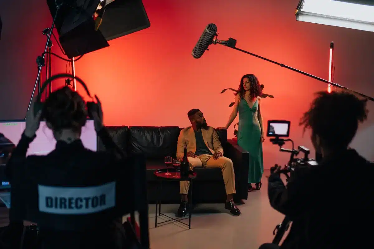 Two people collaborating on a film set, one directing and one performing, sharing creative focus.