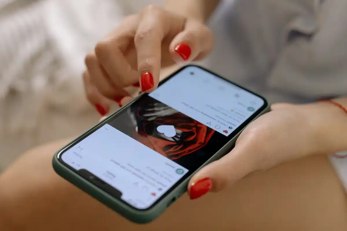 Person scrolling through social media on phone, showing online comments and trending hashtags about reality TV drama