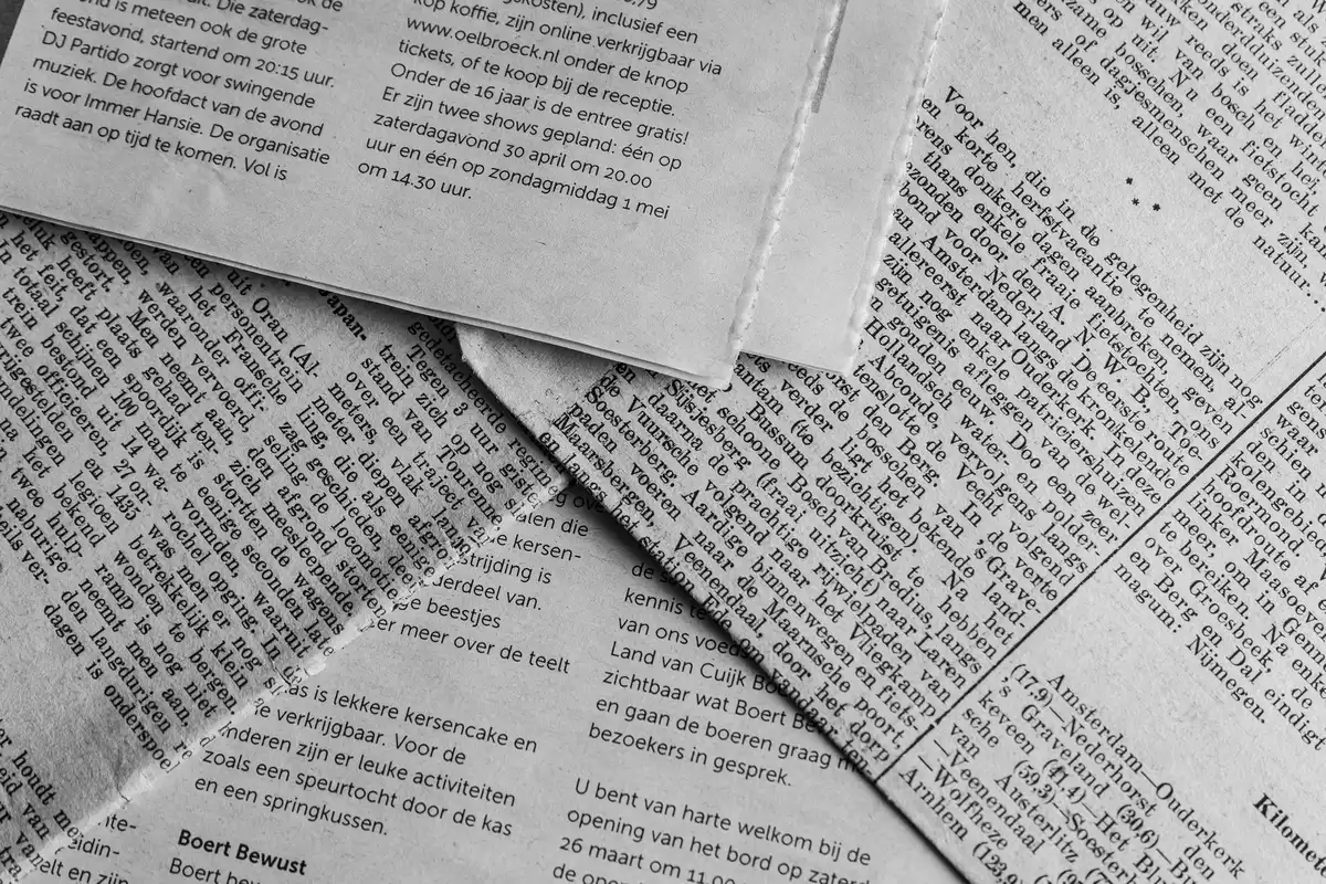 Stack of newspapers and digital news headlines showing varied editorial coverage and framing