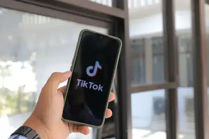 Person scrolling through social media reactions on a smartphone with visible engagement icons