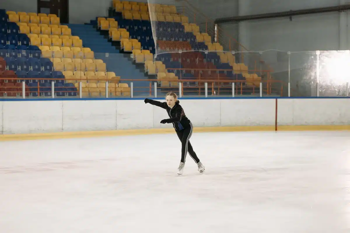 Zwei Schauspielerinnen trainieren Eiskunstlaufen auf dem Eis mit technischem Coaching
