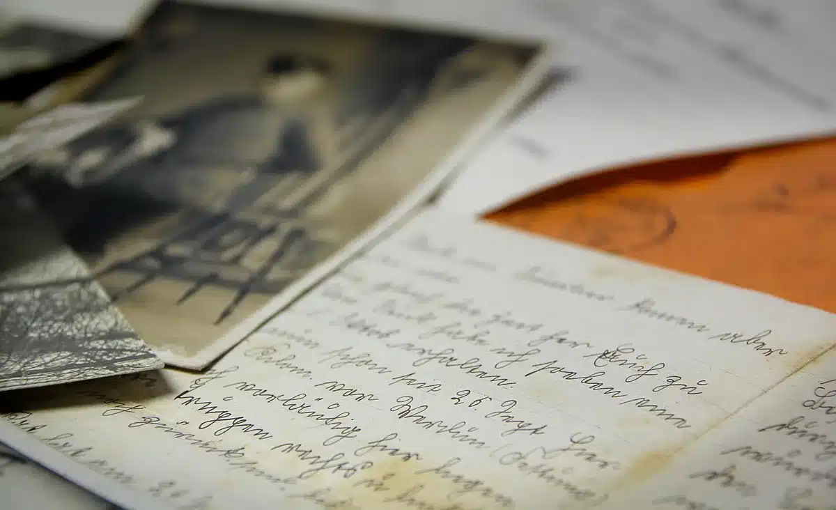 Handwritten letter and vintage communication items on a wooden surface