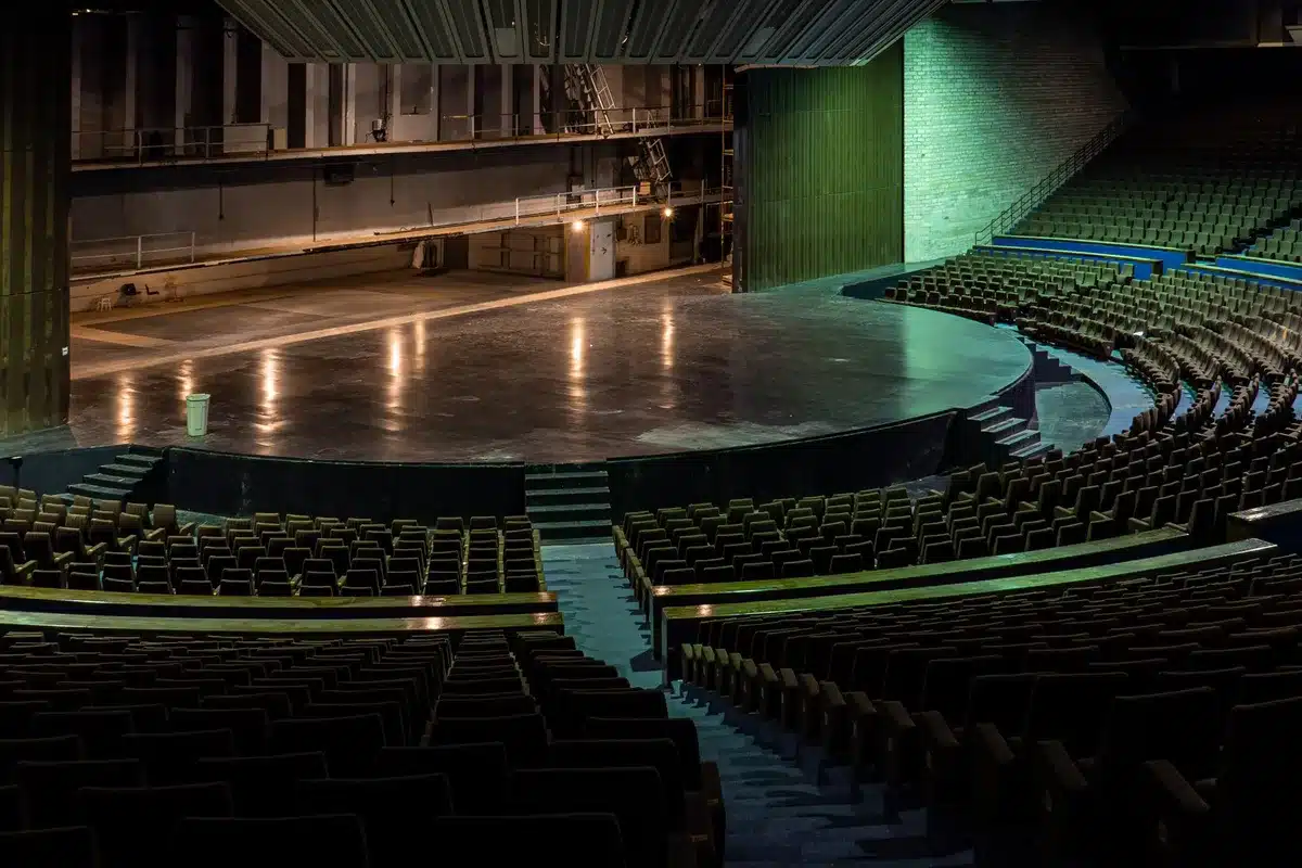 Empty concert venue with dark audience seating and an unlit stage
