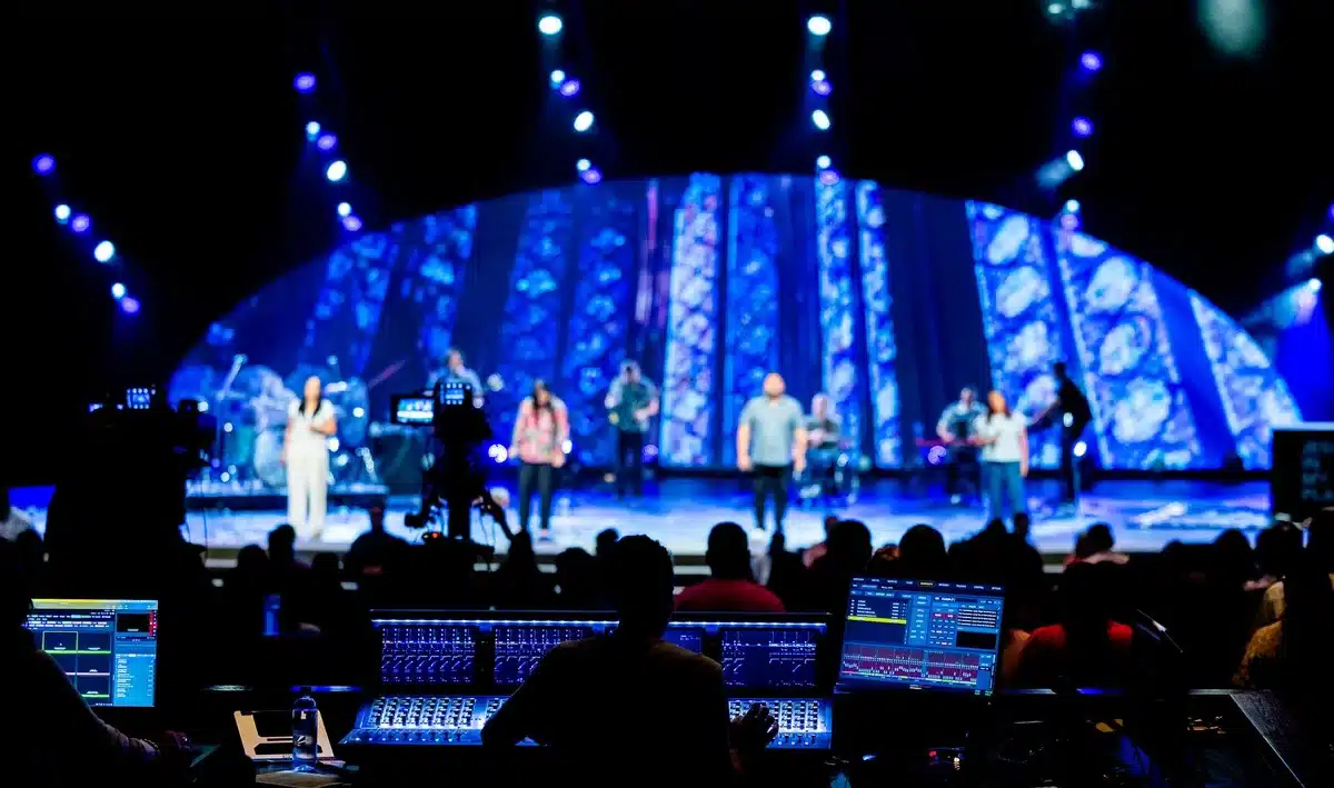 Stage crew member attending to a performer during a concert performance