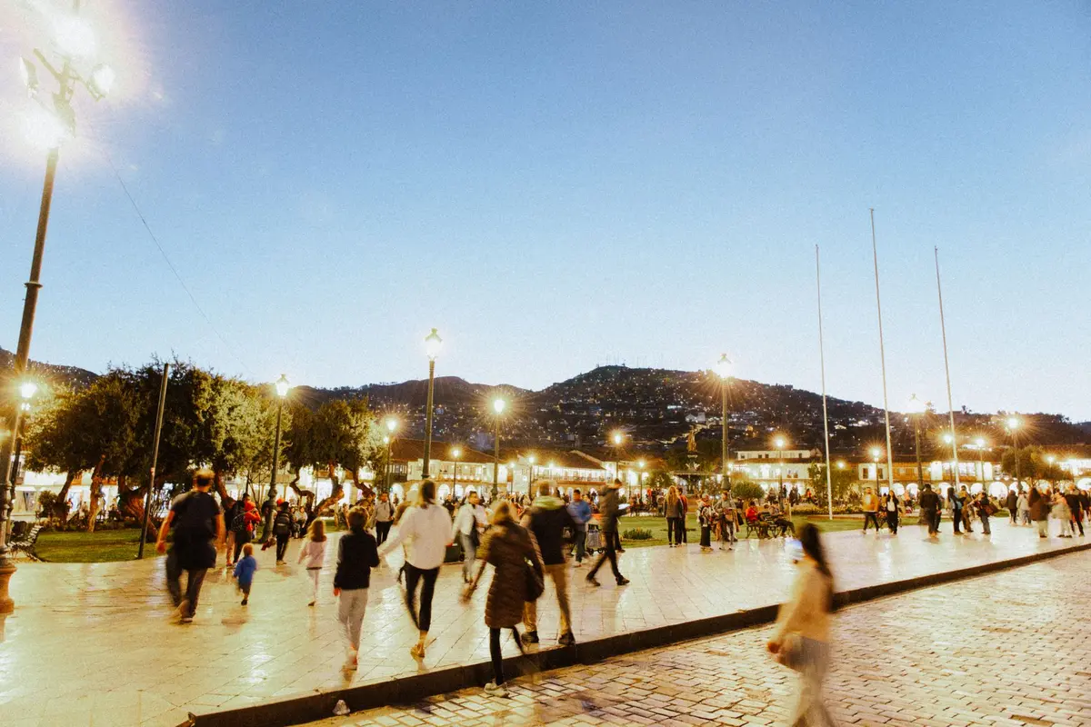 Vibrant European city plaza with lively crowds and historic architecture in evening light.