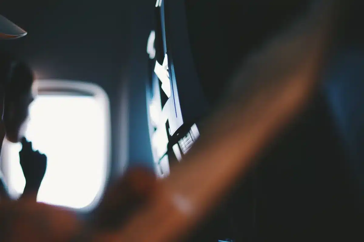 Airplane cabin interior with empty seatback screen panel and window light