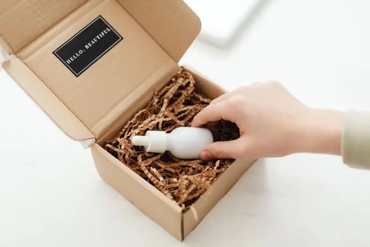 Branded cosmetic product packaging with promotional materials laid out