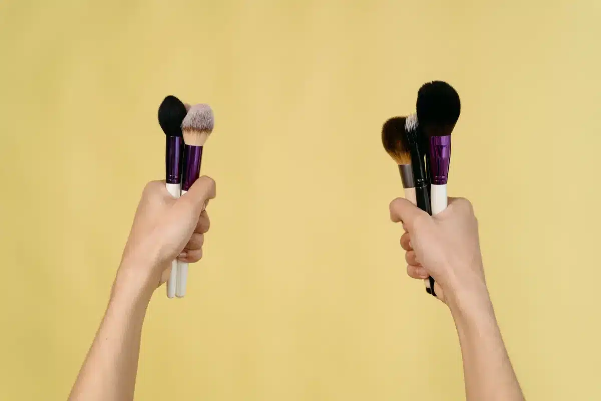 Makeup artist applying contour with precision brush on anonymous face with soft lighting