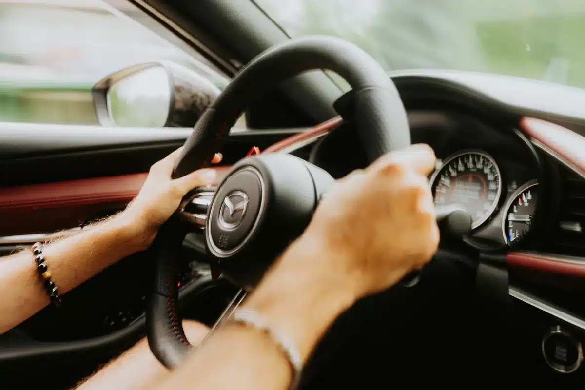 Driver's hands on steering wheel in stock car cockpit during race