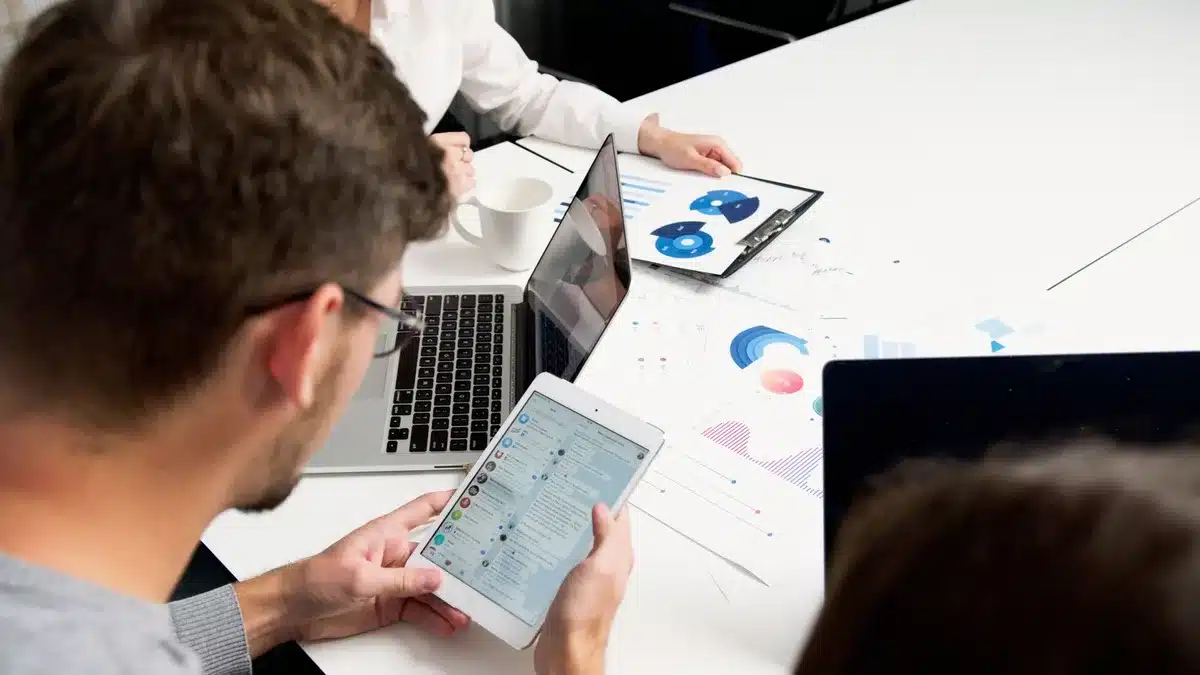 Professionisti che collaborano intorno a documenti e schermi in un ambiente di ufficio moderno