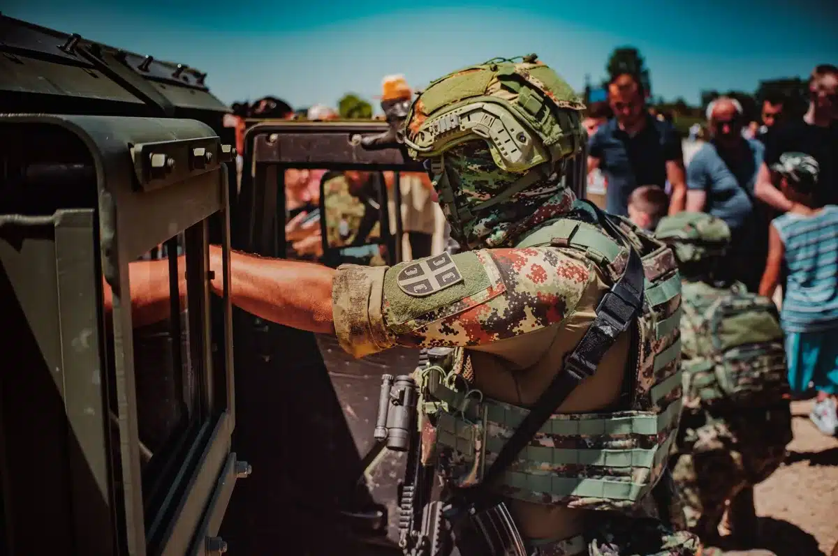 Masas de personas en una frontera con presencia militar y fuerzas de seguridad.