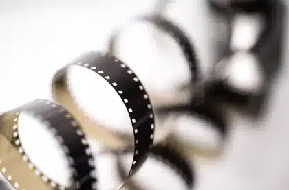 Editing bay with projector, film equipment and scattered news clippings on a table