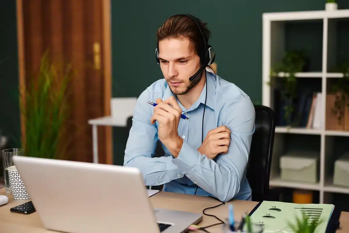 Person gesturing at a laptop showing a chatbot conversation, appearing frustrated