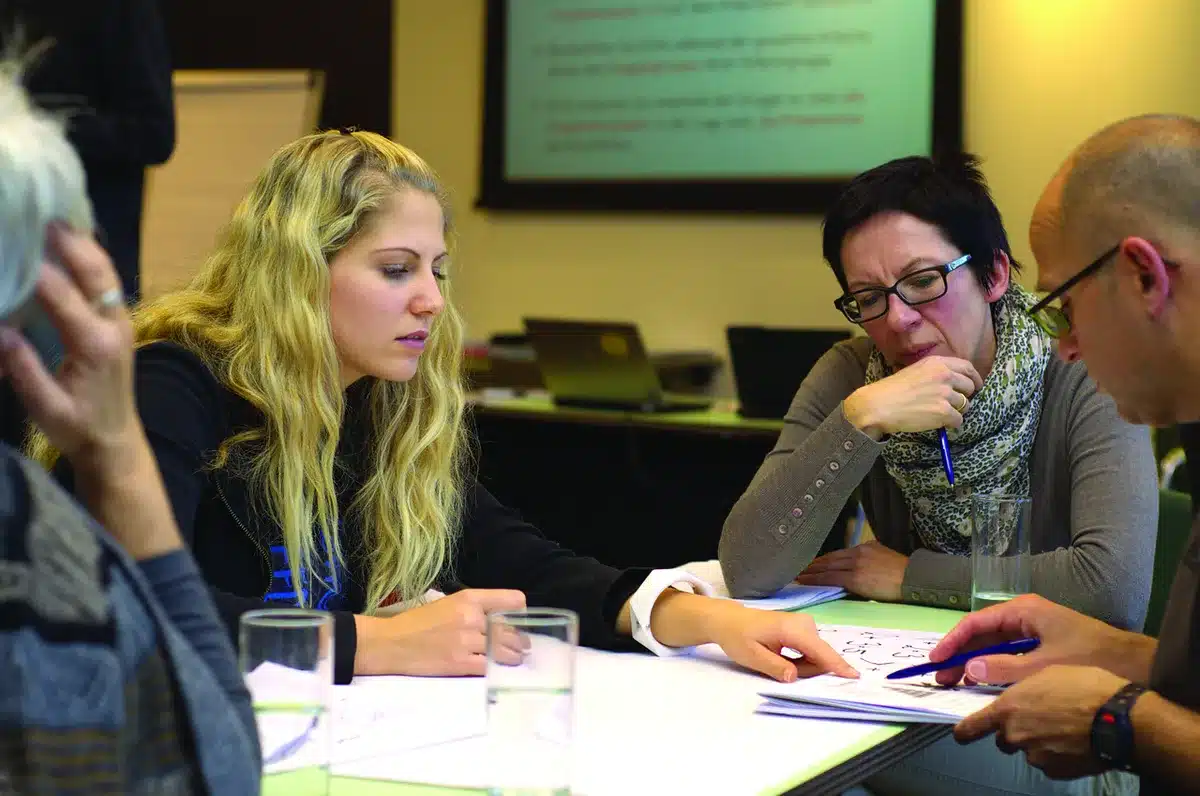 Small team reviewing customer call notes and product samples in a meeting