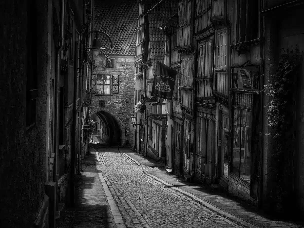 Tourists strolling a narrow European street in mild spring weather
