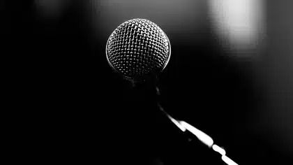 Silhouette of a host at a studio desk with microphone and music memorabilia