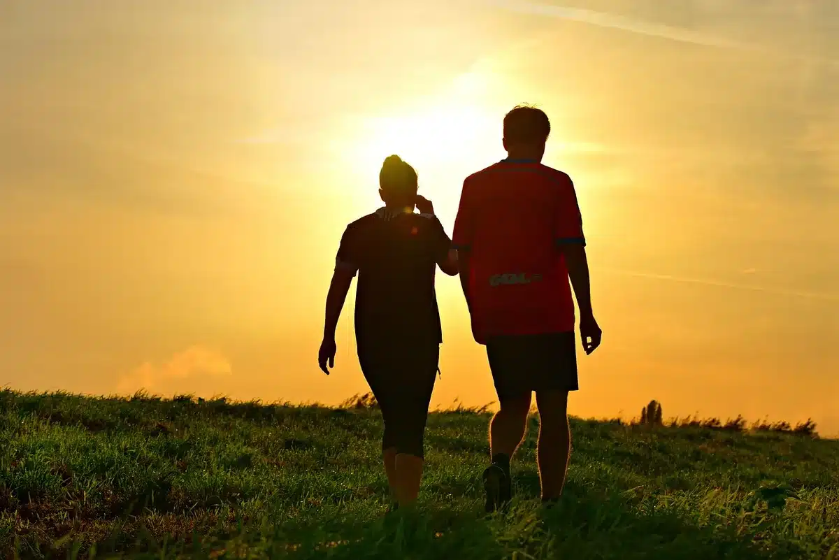 Two people walking side-by-side with hands briefly clasped at a public event