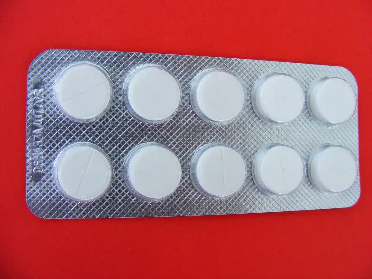 Close-up of assorted pills and a small folded packet on a table