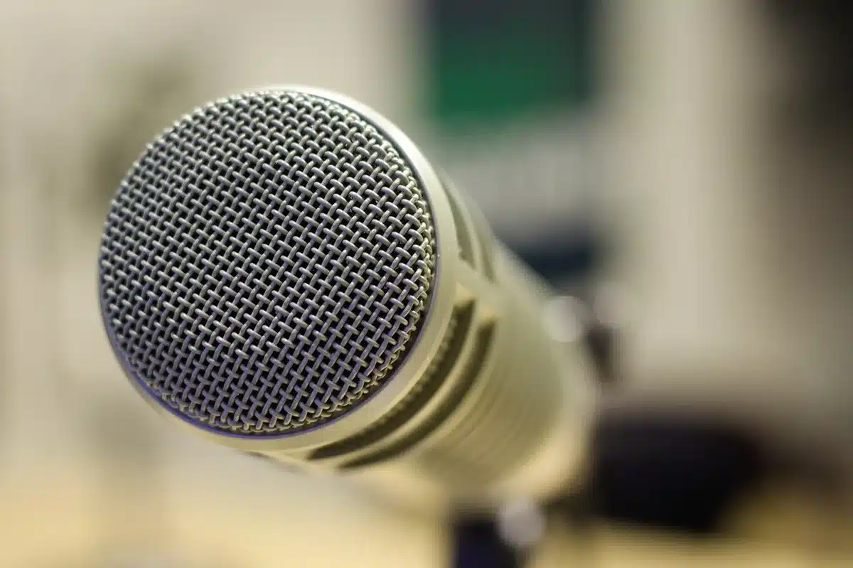 Microphone and headphones on a studio desk with a bright window view