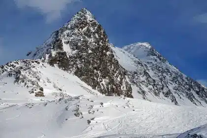 Skier descending a snowy mountain slope in winter conditions