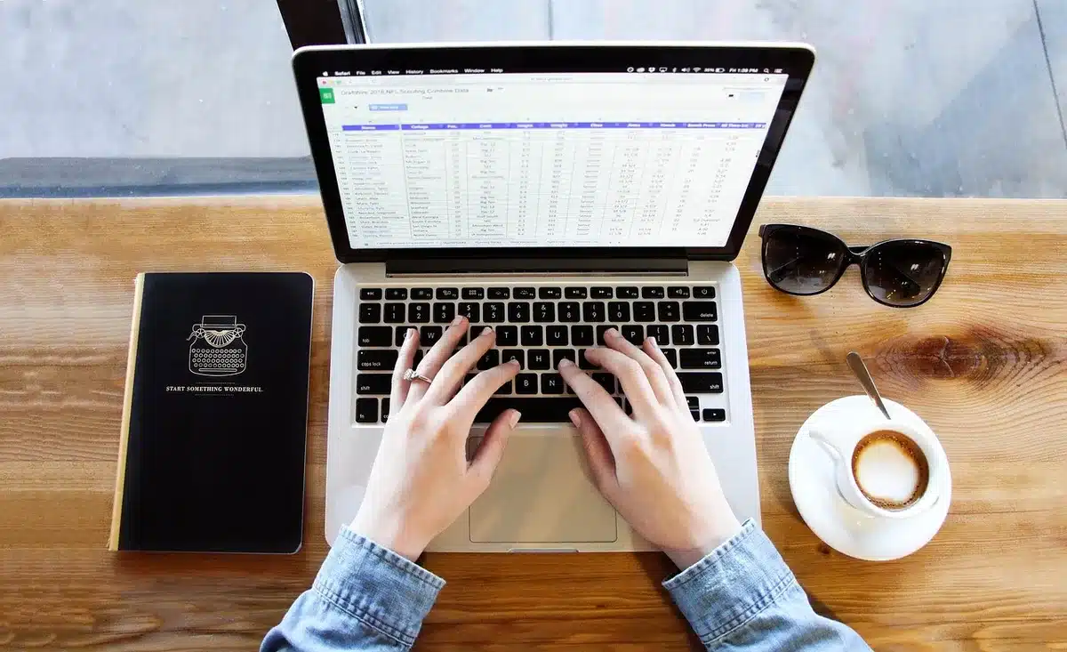 Person saving screenshots on a laptop and taking notes