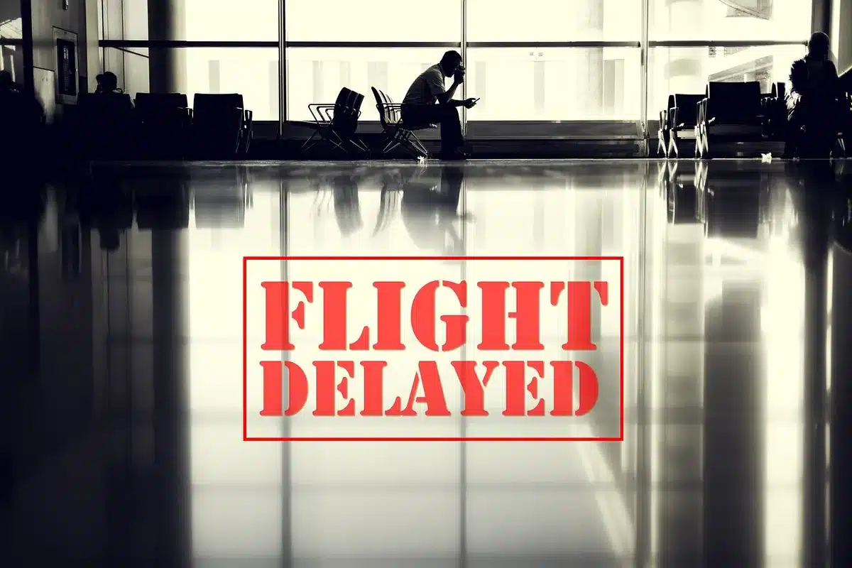 Passenger at a gate taking photos and notes during a flight delay